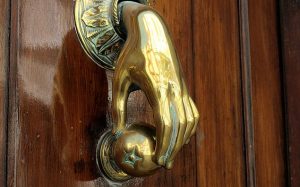Brass hand holding an Apple