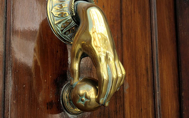 Brass hand holding an Apple